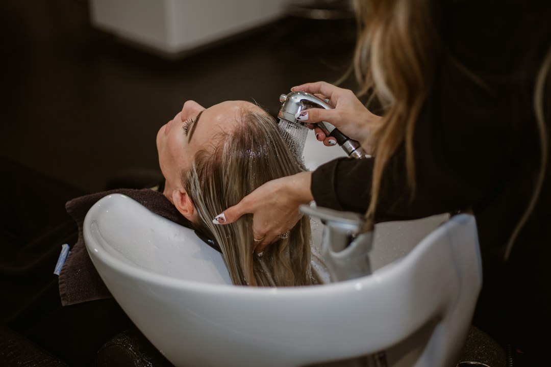 Coiffeuse réalisant une coupe dans un salon