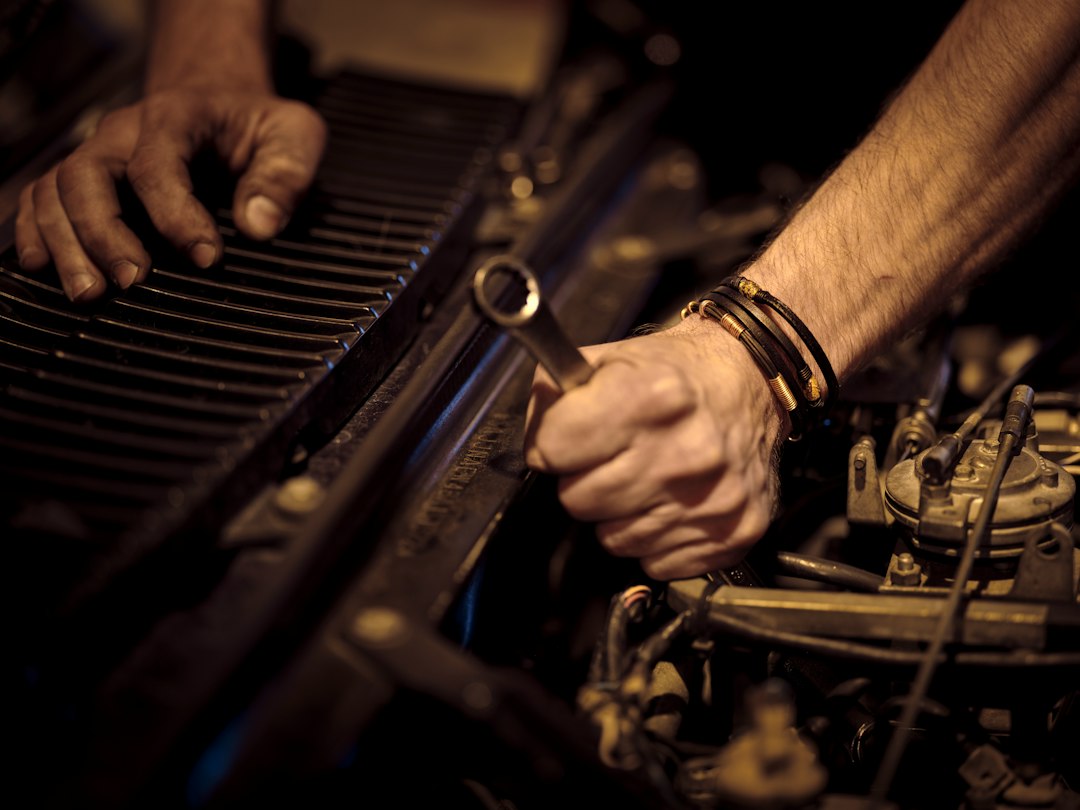 Mains d’un mécanicien travaillant sur un moteur
